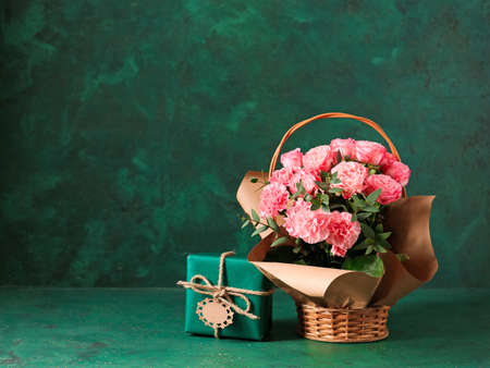 Basket with bouquet for Mother's Day and gift on tableの写真素材
