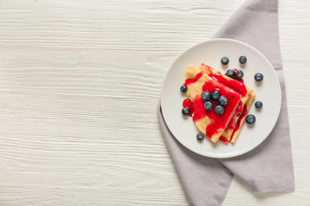 Tasty blini with berries on tableの写真素材
