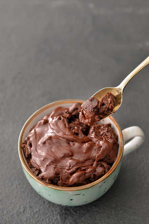 Eating of chocolate mug cake on dark backgroundの写真素材
