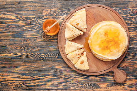 Tasty blini with honey on tableの写真素材