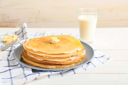 Tasty blini with butter and milk on tableの写真素材