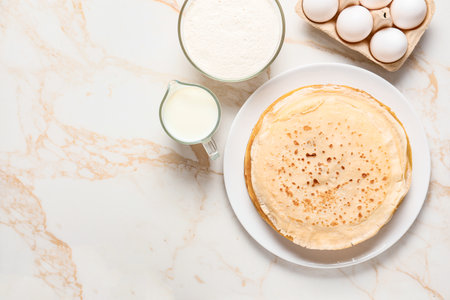 Plate with tasty blini and ingredients on tableの写真素材