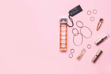Bottle of perfume for sale with makeup cosmetics and accessories on color backgroundの写真素材