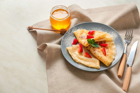 Tasty blini with berries and honey on tableの写真素材