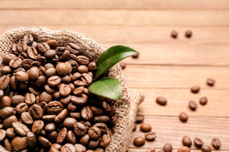 Bag with coffee beans on wooden background, closeupの写真素材
