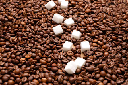 Coffee beans with sugar on tableの写真素材