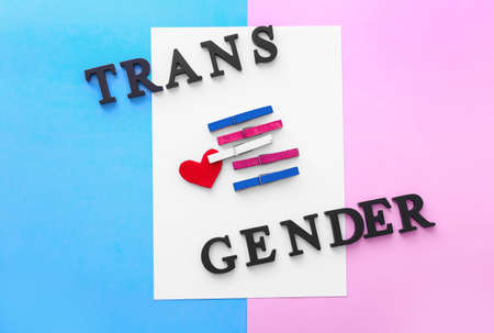 Paper sheet with pegs and text TRANS GENDER on color backgroundの写真素材