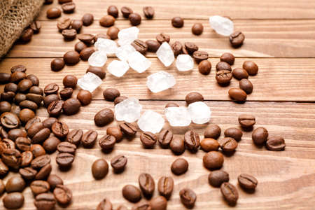 Coffee beans with sugar on wooden backgroundの写真素材