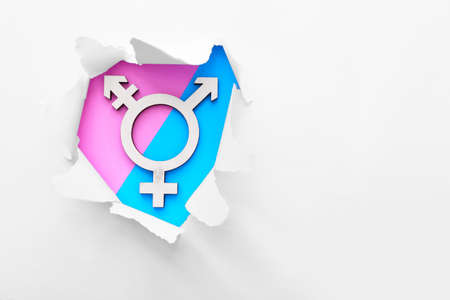 Symbol of transgender visible through torn paper on color backgroundの写真素材