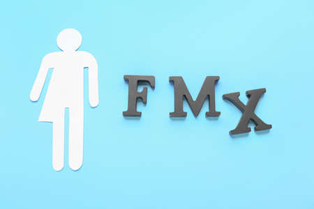Paper figure of transgender and letters F, M, X on color backgroundの写真素材