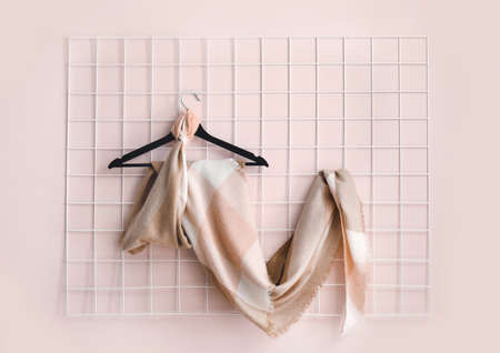 Hanger with beautiful scarf on light wallの写真素材