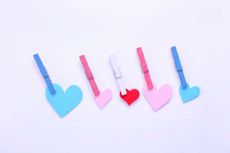 Pegs with paper hearts on white background. Concept of transgenderの写真素材