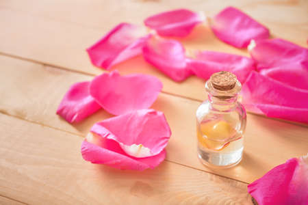 Bottle of rose essential oil on tableの写真素材