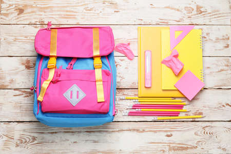 School backpack and stationery on wooden backgroundの写真素材