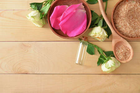 Bottle of rose essential oil and sea salt on tableの写真素材