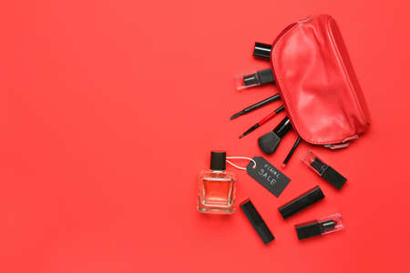 Bottle of perfume with makeup cosmetics and bag on color backgroundの写真素材