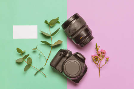 Modern photo camera with card on color backgroundの写真素材
