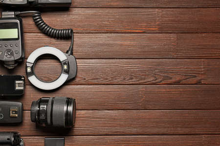Modern photographer's equipment on wooden background