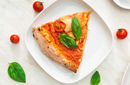 Plate with slice of delicious pizza Margherita on tableの写真素材