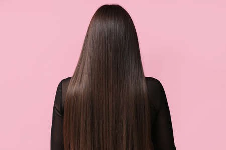 Young woman with beautiful straight hair on color backgroundの写真素材