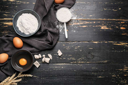 Ingredients for dough on dark wooden background