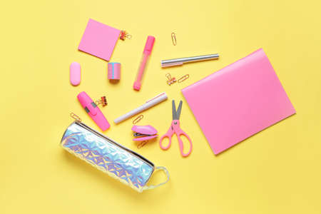 Pencil case and stationery on color background