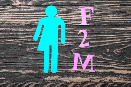 Transgender figure and abbreviation F2M on wooden backgroundの写真素材