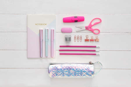 Pencil case and school stationery on wooden background