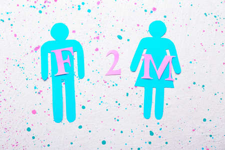 Male and female figures and abbreviation F2M on white background. Concept of transgenderの写真素材