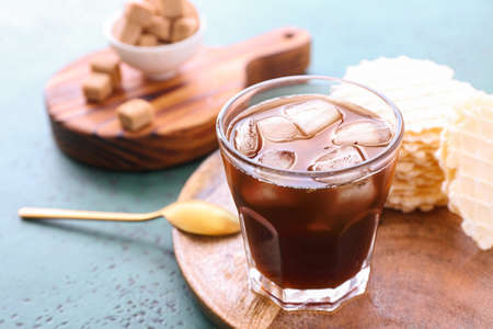 Glass of tasty iced coffee on table