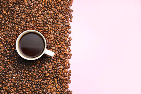 Cup of hot coffee and beans on color backgroundの写真素材