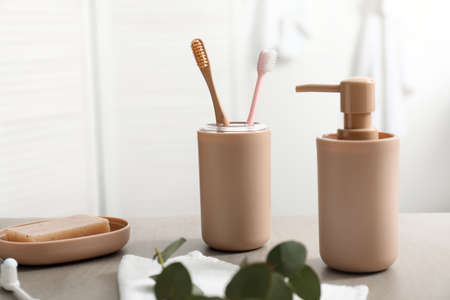 Tooth brushes and soap on table in bathroomの写真素材