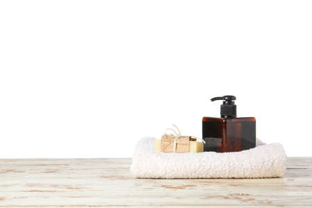 Shampoo, soap and towel on table against white backgroundの写真素材