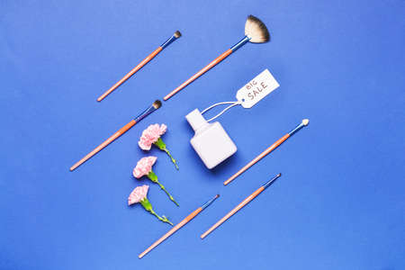 Bottle of perfume with makeup brushes on color backgroundの写真素材