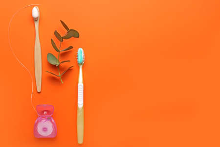 Tooth brushes with paste and floss on color backgroundの写真素材