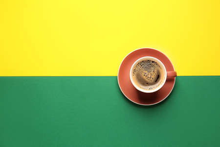 Cup of hot coffee on color backgroundの写真素材