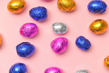 Sweet chocolate eggs on color background