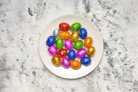 Plate with sweet chocolate eggs on light backgroundの写真素材