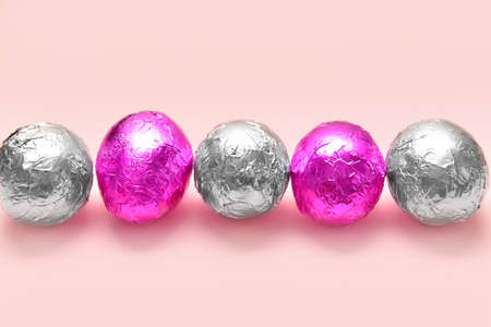 Sweet chocolate eggs on color background