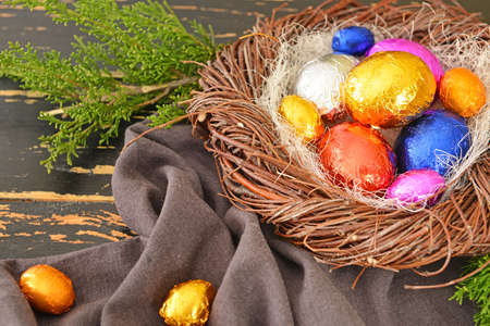 Nest with sweet chocolate eggs on wooden backgroundの写真素材