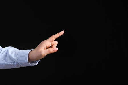 Young businesswoman using virtual screen on dark backgroundの写真素材