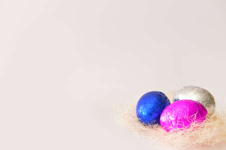Nest with sweet chocolate eggs on white backgroundの写真素材