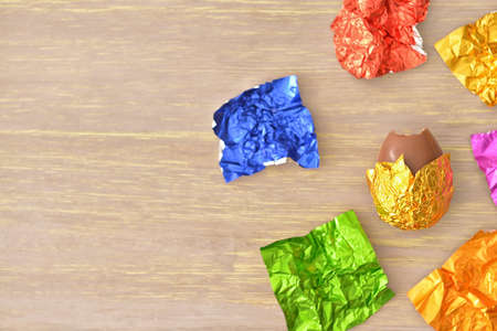 Sweet chocolate egg and foil on wooden backgroundの写真素材