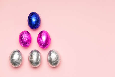 Sweet chocolate eggs on color background