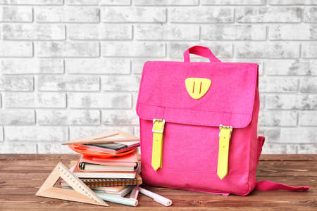 School backpack and stationery on wooden tableの写真素材
