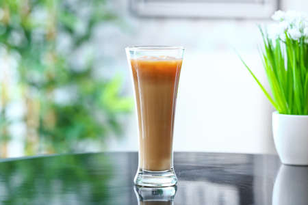 Glass of tasty iced coffee on table in cafeの写真素材