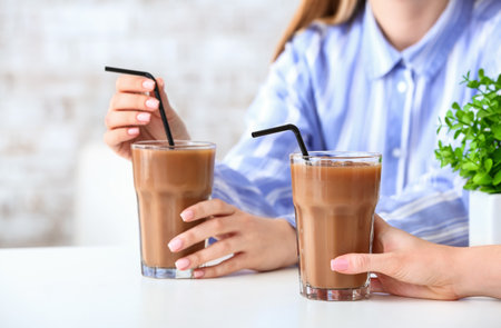 Women with glasses of tasty iced coffee in cafe, closeupの写真素材