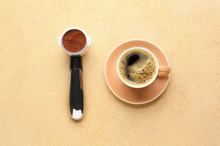 Cup of hot coffee and scoop on color backgroundの写真素材