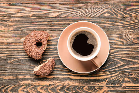 Cup of hot coffee and donut on wooden backgroundの写真素材
