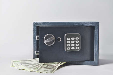 Modern safe with dollar banknotes on light backgroundの写真素材